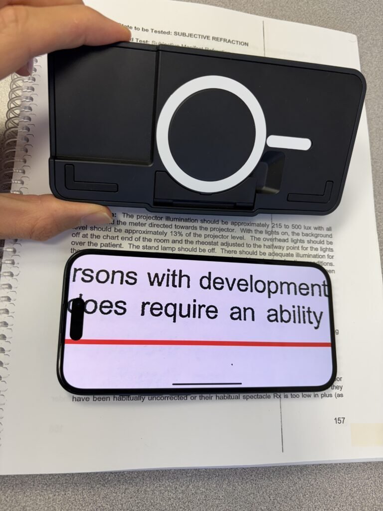Optaro digital magnifier attached to an iPhone, showing enlarged text on the screen, designed for low vision users