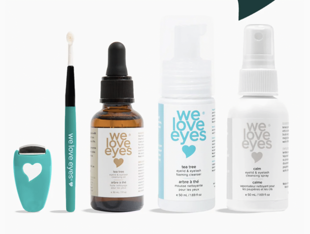 "A collection of 'We Love Eyes' products, including a teal eyelash curler, a teal brush, a brown dropper bottle of tea tree eyelid & eyelash cleansing oil, a white pump bottle of tea tree eyelid & eyelash foaming cleanser, and a white spray bottle of calm eyelid & eyelash cleansing spray, all against a neutral background."